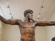 the bronze statue of Zeus or Poseidon, found in the sea off of Evia, which depicts one of the gods (no one really knows which one) with his arms outstretched and holding a thunderbolt or trident in his right hand